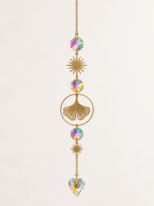 Gold-tone ginkgo leaf and heart sun catcher on a light background